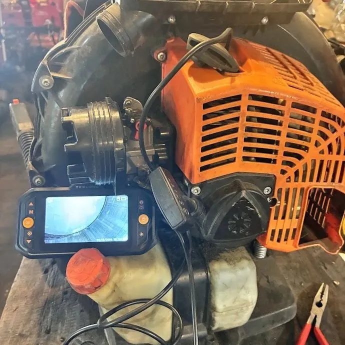 Backpack leaf blower being checked inside the cylinder with an inspection camera