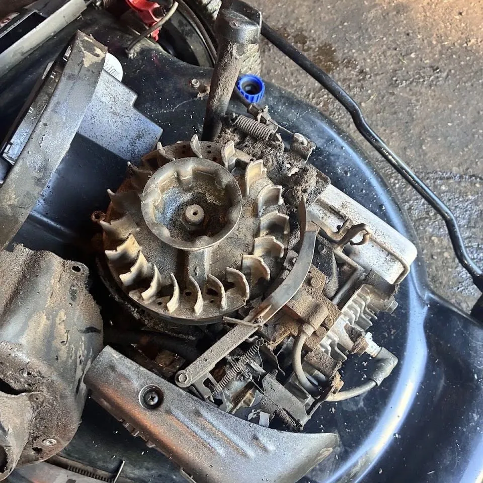 Lawn mower engine flywheel exposed during a tune-up